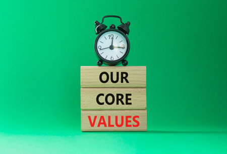 Our core values symbol. Concept words Our core values on wooden blocks. Beautiful green background with alarm clock. Business and Our core values concept. Copy space.の写真素材