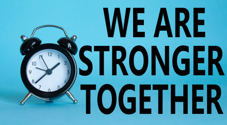 We are stronger together symbol. Beautiful blue background with alarm clock with words We are stronger together. Business and We are stronger together concept. Copy space.の写真素材