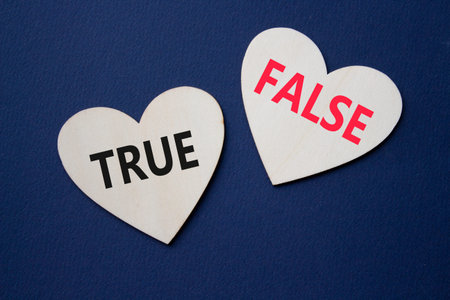 True or False symbol. Concept word True or False on wooden hearts. Beautiful deep blue background. Business and True or False concept. Copy spaceの写真素材