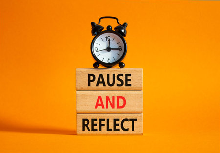 Pause and Reflect symbol. Concept words Pause and Reflect on wooden blocks. Beautiful orange...
