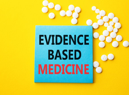 Evidence Based Medicine symbol. Concept word Evidence Based Medicine on blue note. Beautiful yellow background with pills. Medicine and Evidence Based Medicine concept. Copy spaceの写真素材