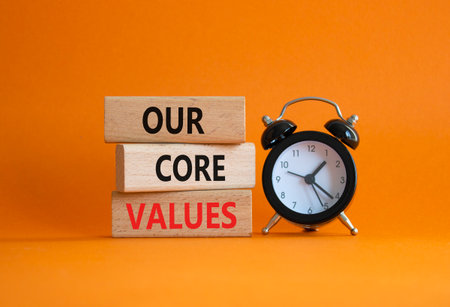 Our core values symbol. Concept words Our core values on wooden blocks. Beautiful orange background with alarm clock. Business and Our core values concept. Copy space.の写真素材