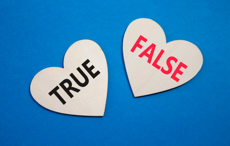 True or False symbol. Concept word True or False on wooden hearts. Beautiful blue background. Business and True or False concept. Copy spaceの写真素材