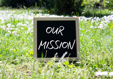 Our Mission symbol. Concept word Our Mission on chalk blackboard. Beautiful meadow background. Business and Our Mission concept. Copy space.の写真素材