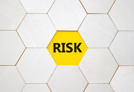 Risk symbol. Concept word Risk on wooden comb puzzle. Beautiful yellow background. Business and Risk...