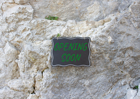 Opening soon symbol. Stone wall with words Opening soon. Beautiful stone background. Business and...