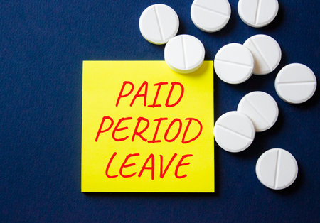 Paid Period Leave symbol. Concept words Paid Period Leave on yellow note. Beautiful deep blue background with pills. Healthcare and Paid Period Leave concept. Copy space.の写真素材