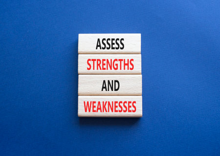 Strengths and Weaknesses symbol. Wooden blocks with words Assess Strengths and Weaknesses. Beautiful deep blue background. Business and Assess Strengths and Weaknesses concept. Copy space.の写真素材