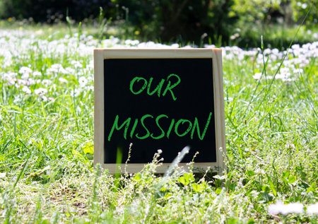 Our Mission symbol. Concept word Our Mission on chalk blackboard. Beautiful meadow background. Business and Our Mission concept. Copy space.の写真素材