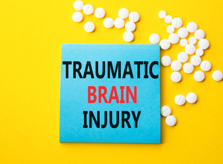 Traumatic Brain Injury symbol. Concept words Traumatic Brain Injury on blue note. Beautiful yellow background with pills. Healthcare and Traumatic Brain Injury concept. Copy space.の写真素材