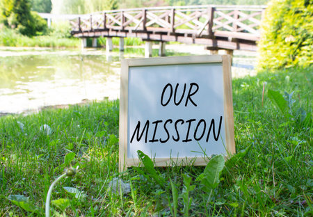 Our Mission symbol. Concept word Our Mission on white chalk blackboard. Beautiful meadow background with bridge. Business and Our Mission concept. Copy space.の写真素材