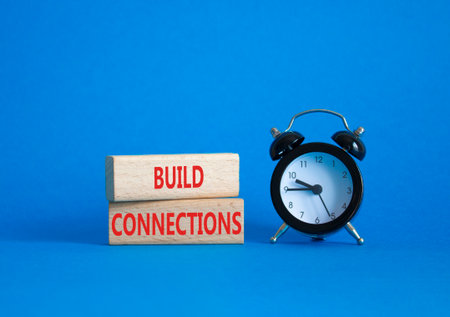 Build Connections symbol. Concept word Build Connections on wooden blocks. Beautiful blue background with alarm clock. Business and Build Connections concept. Copy spaceの写真素材