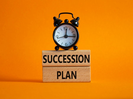 Succession Plan symbol. Wooden blocks with words Succession Plan. Beautiful orange background with alarm clock. Business and Succession Plan concept. Copy space.の写真素材