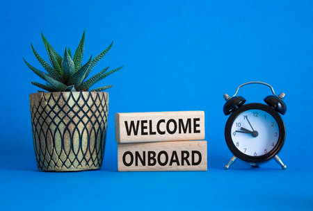 Welcome onboard symbol. Concept words Welcome on board on wooden blocks. Beautiful blue background with alarm clock and succulent plant. Business and Welcome onboard concept. Copy space.の写真素材
