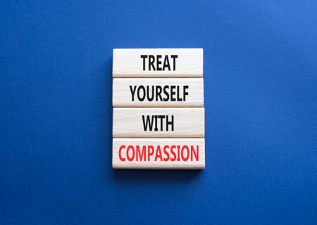 Treat yourself with compassion symbol. Concept words Treat yourself with compassion on wooden blocks. Beautiful deep blue background. Medicine concept. Copy space.の写真素材