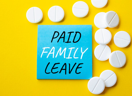 Paid Family Leave symbol. Concept words Paid Family Leave on blue note. Beautiful yellow background with pills. Healthcare and Paid Family Leave concept. Copy space.の写真素材