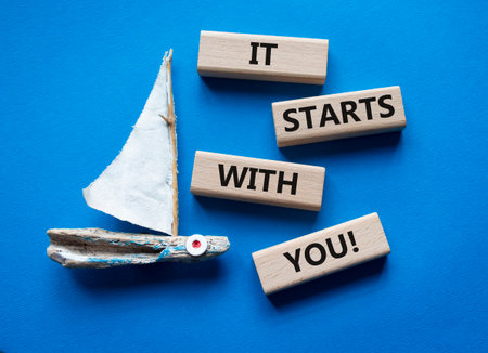 It starts with you symbol. Wooden blocks with words It starts with you. Beautiful blue background with boat. Business and It starts with you concept. Copy space.の写真素材