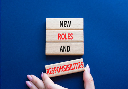 New roles and responsibilities symbol. Wooden blocks with words New roles and responsibilities. Beautiful deep blue background. Businessman hand. Business concept. Copy space.の写真素材