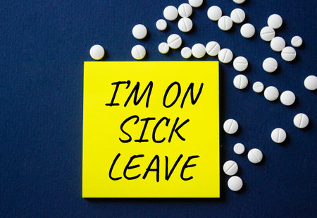 Sick leave symbol. Concept word I am on sick leave on yellow note. Beautiful deep blue background...