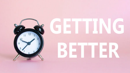 Getting better symbol. Beautiful pink background with alarm clock. Business and Getting better concept. Copy space.の写真素材