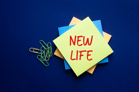New life symbol. Yellow sticky note with concept words New Life. Beautiful deep blue background. Business and New life concept. Copy space.の写真素材