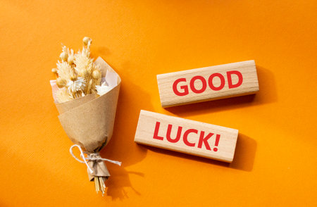 Good luck symbol. Wooden blocks with words Good luck. Beautiful orange background with bouquet of flowers. Business and Good luck concept. Copy space.の写真素材