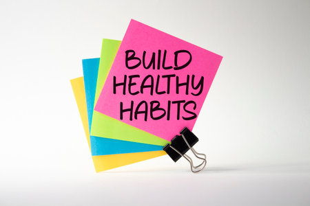 Healthy habits symbol. Concept word Build Healthy habits on pink sticky note. Beautiful white background. Healthy lifestyle and Healthy habits concept. Copy spaceの写真素材