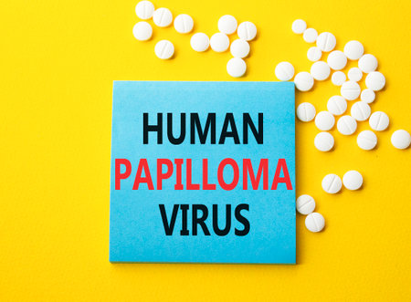 Human Papilloma Virus symbol. Concept word Human Papilloma Virus on blue note. Beautiful yellow background with pills. Medicine and Human Papilloma Virus concept. Copy spaceの写真素材