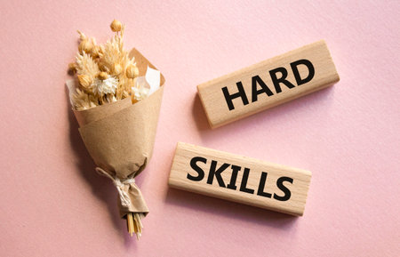 Hard skills symbol. Wooden blocks with words Hard skills. Beautiful pink background with bouquet of flowers. Business and Hard skills concept. Copy space.の写真素材