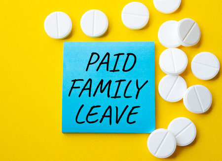 Paid Family Leave symbol. Concept words Paid Family Leave on blue note. Beautiful yellow background with pills. Healthcare and Paid Family Leave concept. Copy space.の写真素材