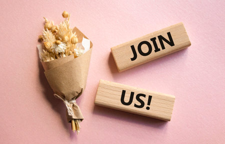 Join us symbol. Concept word Join us on wooden blocks. Beautiful pink background with bouquet of flowers. Business and Join us concept. Copy spaceの写真素材