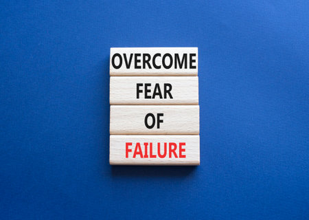 Fear of failure symbol. Concept words Overcome Fear of failure on wooden blocks. Beautiful deep blue background. Business and Fear of failure concept. Copy space.の写真素材