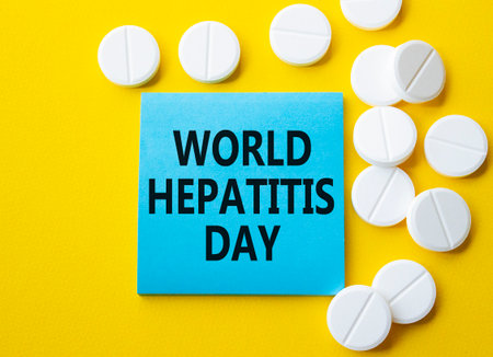 World Hepatitis Day symbol. Concept words World Hepatitis Day on blue note. Beautiful yellow background with pills. Healthcare and World Hepatitis Day concept. Copy space.の写真素材
