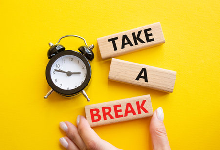 Take a break symbol. Concept words Take a break on wooden blocks. Businessman hand. Beautiful yellow...