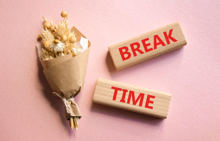 Break Time symbol. Concept word Break Time on wooden blocks. Beautiful pink background with bouquet of flowers. Business and Break Time concept. Copy spaceの写真素材