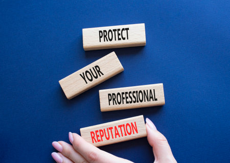 Professional Reputation symbol. Concept words Protect Your Professional Reputation on wooden blocks. Beautiful deep blue background. Businessman hand. Business concept. Copy spaceの写真素材