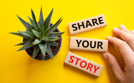 Share your story symbol. Wooden blocks with words Share your story. Beautiful yellow background with succulent plant. Businessman hand. Business and Share your story concept. Copy space.の写真素材
