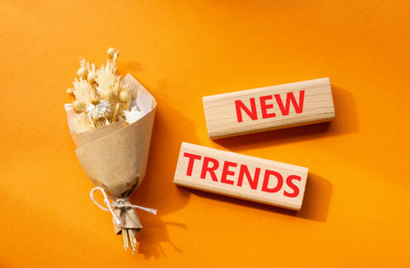 New Trends symbol. Wooden blocks with words New Trends. Beautiful orange background. Business and New Trends concept. Copy space.の写真素材