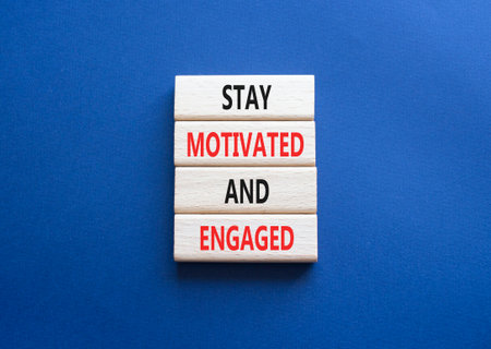 Stay Motivated and Engaged symbol. Concept words Stay Motivated and Engaged on wooden blocks. Beautiful deep blue background. Business concept. Copy spaceの写真素材