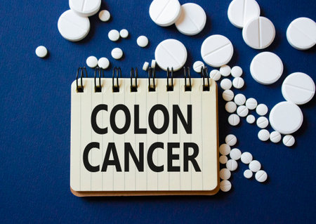 Colon Cancer symbol. Concept word Colon Cancer on notebook. Beautiful deep blue background with pills. Medicine and Colon Cancer concept. Copy spaceの写真素材