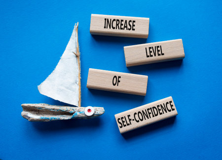 Productivity symbol. Wooden blocks with words Increase your Level of Self-Confidence. Beautiful blue background with boat. Business concept. Copy space.の写真素材