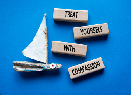 Treat yourself with compassion symbol. Concept words Treat yourself with compassion on wooden blocks. Beautiful blue background. Copy space.の写真素材