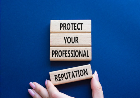Professional Reputation symbol. Concept words Protect Your Professional Reputation on wooden blocks. Beautiful deep blue background. Businessman hand. Business concept. Copy spaceの写真素材