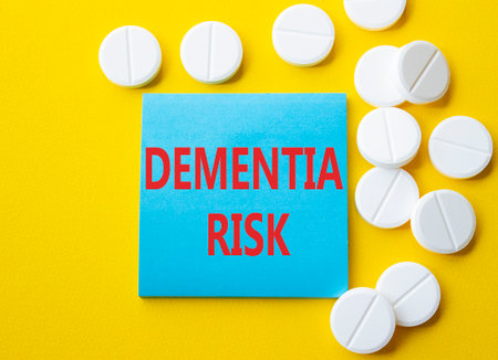 Dementia Risk symbol. Concept word Dementia Risk on blue note. Beautiful yellow background with pills. Medicine and Dementia Risk concept. Copy spaceの写真素材