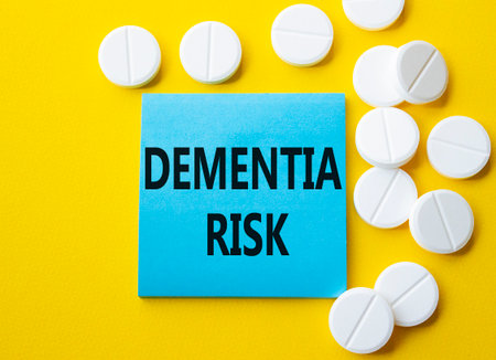 Dementia Risk symbol. Concept word Dementia Risk on blue note. Beautiful yellow background with pills. Medicine and Dementia Risk concept. Copy spaceの写真素材