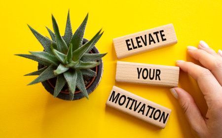 Motivation symbol. Wooden blocks with words. Beautiful yellow background with succulent plant. Businessman hand. Business concept. Copy space.の写真素材