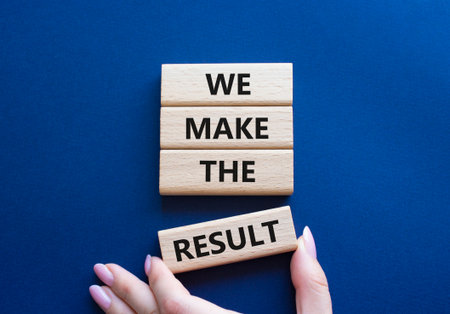 We make the result symbol. Concept words We make the result on wooden blocks. Beautiful deep blue background. Businessman hand. Business concept. Copy space.の写真素材