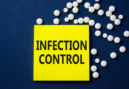Infection Control symbol. Concept word Infection Control on yellow note. Beautiful deep blue background with pills. Medicine and Infection Control concept. Copy spaceの写真素材