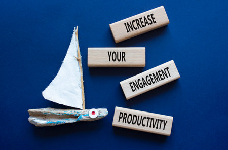 Productivity symbol. Wooden blocks with words Increase your Engagement Productivity. Beautiful deep blue background with boat. Business concept. Copy space.の写真素材