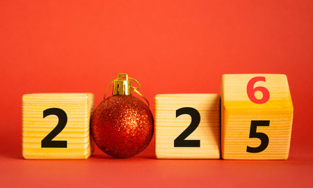 2026 New Year symbol. Businessman turns wooden cube and changes Year 2025 to 2026. Beautiful red...